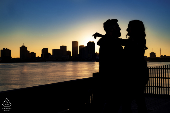 New Orleans Crescent Park Post-Proposal-Porträtfotos eines glücklichen Louisiana-Paares Silhouette mit Blick auf die Skyline bei Sonnenuntergang