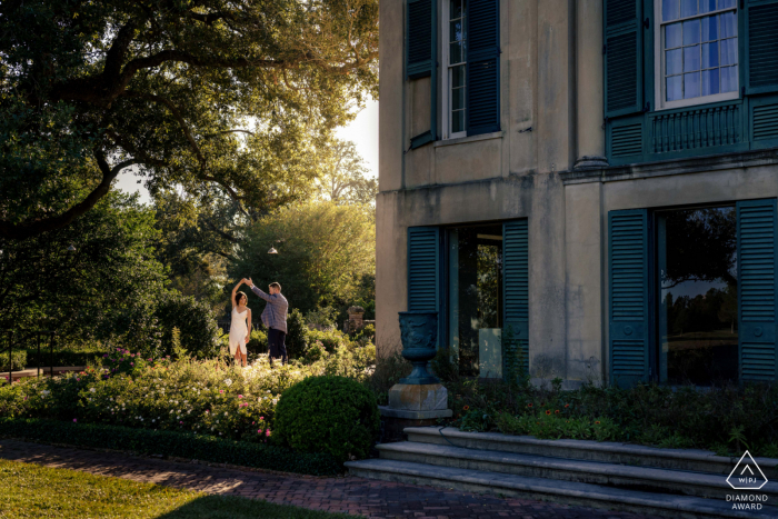Longue Vue House and Gardens post proposal photography showing a smiling New Orleans couple during a scene out of The Notebook with Fairy tale dancing in the sunlight Longue Vue House and Gardens post proposal photography showing a smiling New Orleans couple during a scene out of The Notebook with Fairy tale dancing in the sunlight