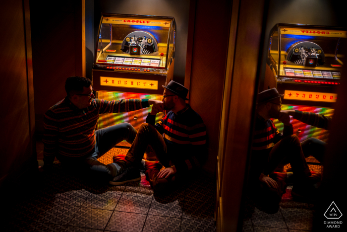 Revival Hotel post proposal portrait session with a Baltimore engagement photographer of a Maryland couple seated in a romantic pose near the juke box 