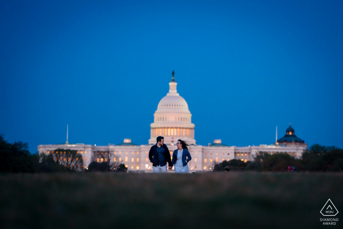 DC Capitol post propozycja portrety z sesji narzeczeńskiej w Waszyngtonie dla pary idącej ręka w rękę po The Mall z Kapitolem w tle