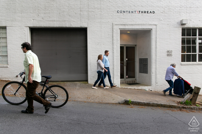 Ein urbanes Fotoshooting vor der Hochzeit in Poncey Highlands, Atlanta, bei dem ein Paar auf dem Bürgersteig spazieren geht