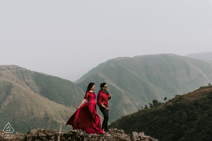 Fotos de noivado aventureiros em Shillong, Meghalaya para um casal posado em um penhasco em roupas vermelhas