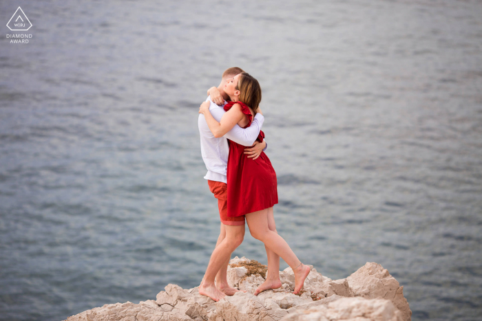 Couple photography in Marseille during a pre wedding engagement shoot at La Baie des Singes created as The couple hug on the edge just above the sea Couple photography in Marseille during a pre wedding engagement shoot at La Baie des Singes created as The couple hug on the edge just above the sea