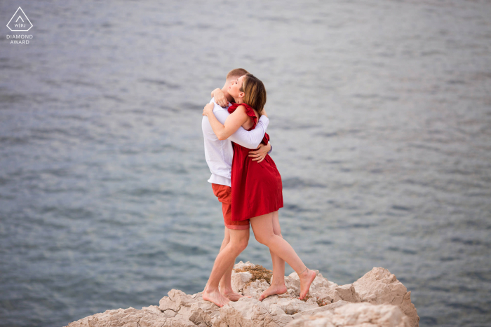 Couple photography in Marseille during a pre wedding engagement shoot at La Baie des Singes created as The couple hug on the edge just above the sea