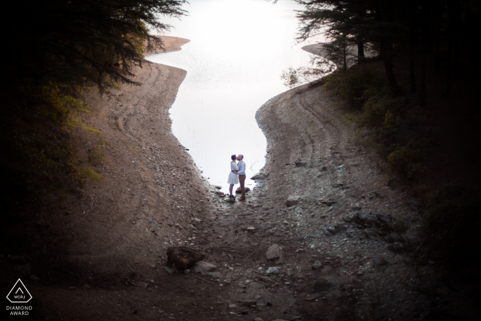 Ein Fotoshooting vor der Hochzeit am Lac du Ternay, Frankreich, das entstanden ist, während das Paar sich an einem See in der Ardèche küsst