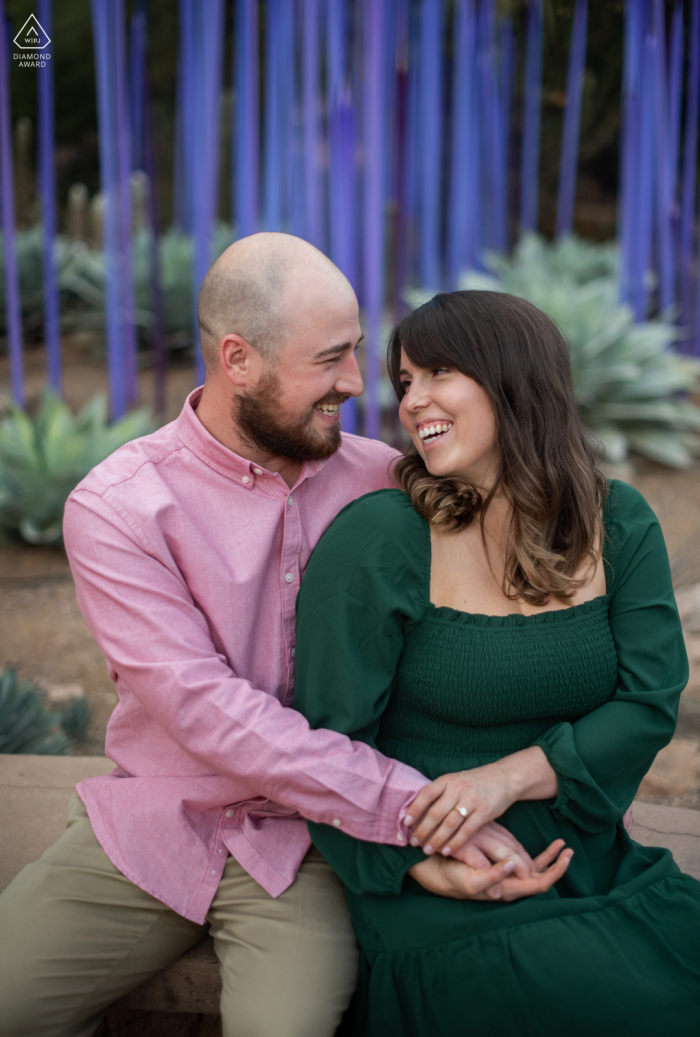 Engagement im Botanischen Garten der Wüste. Ein junges Phoenix-Paar posiert während einer Porträtsitzung vor der Hochzeit und wird mit Chihuly-Kunstwerken fotografiert