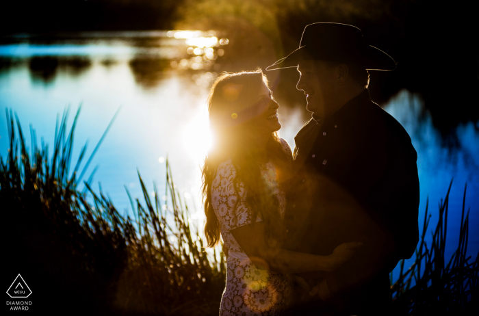 Photos de fiançailles en Arizona. Un couple Gilbert pose au coucher du soleil près de l'eau