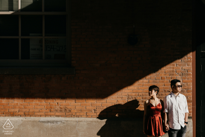 Photographie de couple à Dallas lors d'une séance de fiançailles avant le mariage du couple décentré dans la lumière avec des ombres au-dessus d'eux