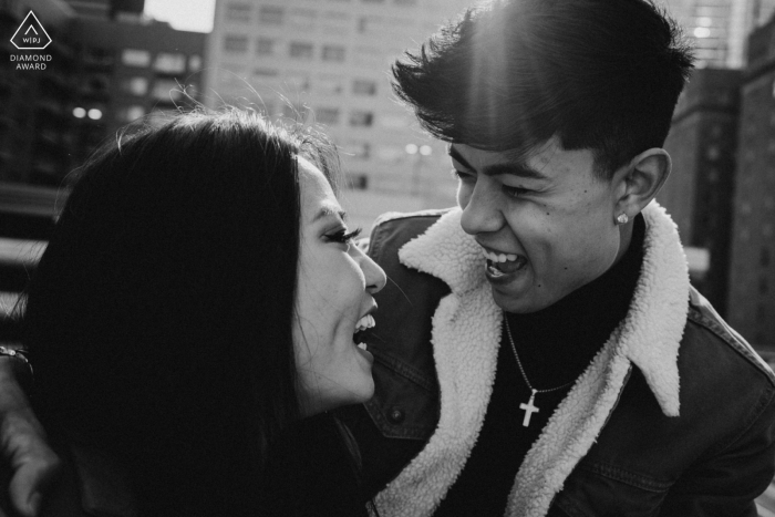 Una sesión de fotos urbana previa a la boda en Houston de una pareja en blanco y negro mirándose y riéndose