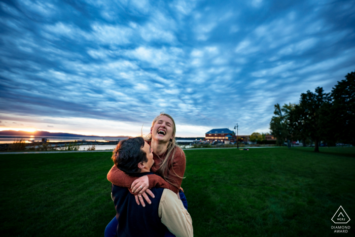 Paarfotografie in Burlington, VT während eines Verlobungsshootings vor der Hochzeit an der Waterfront unter einem wolkenverhangenen Himmel