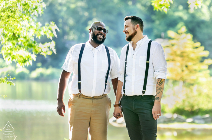 Fotografia de casal em Pine Lake, Geórgia, durante uma sessão de noivado pré-casamento mostrando noivos em suspensórios sorrindo um para o outro Fotografia de casal em Pine Lake, Geórgia, durante uma sessão de noivado pré-casamento mostrando noivos em suspensórios sorrindo um para o outro