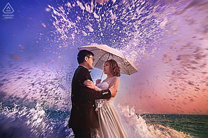 Adventurous engagement photos in Shenzhen, China near the ocean with crashing, splashing waves