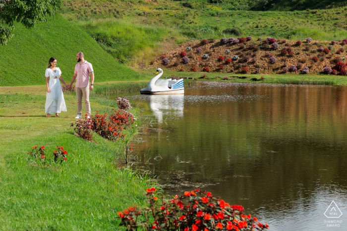 A sunny Sapucaia Engagement Session in Rio de Janeiro on the grass by the lake with a swan boat