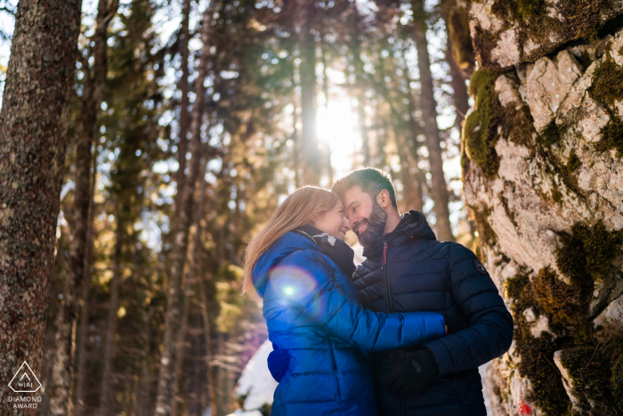 Compromiso del lago Fusine. Una joven pareja de Tarvisio posando durante una sesión de retratos antes de la boda para una foto de amor al atardecer bajo los árboles y la luz del sol