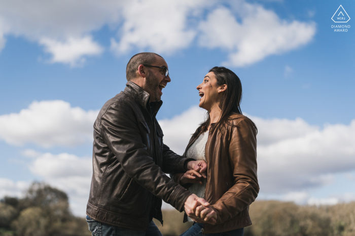 Loire-Atlantique Engagement Photos. Vertou couple posing outdoors in nature below the sky and clouds of France