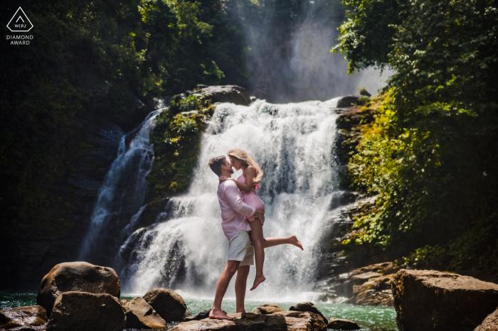 Una fotografía de compromiso después de la propuesta de matrimonio en San José en la Catarata Nauyaca, San Isidro, Pérez Zeledón, Costa Rica, que muestra a la pareja divirtiéndose frente a la increíble caída de agua