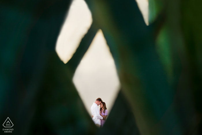 Ein Save-the-Date in Perth. Westaustralien-Porträt des Paares in Grün umrahmt und zusammen lachend