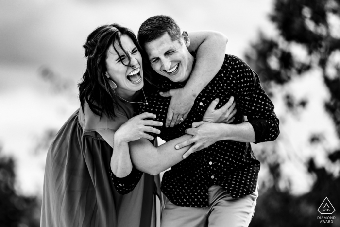 Une séance photo de fiançailles après la proposition de mariage à White Cliffs of Conoy pour un couple partageant un grand rire tout en étant enveloppé l'un avec l'autre