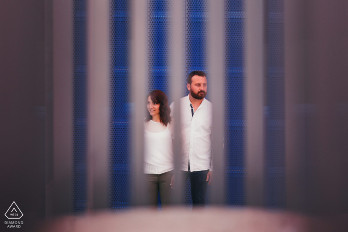 She said yes, post marriage proposal picture session at the University at Nancy in France showing a Couple looking away from each other, photo taken through a grid