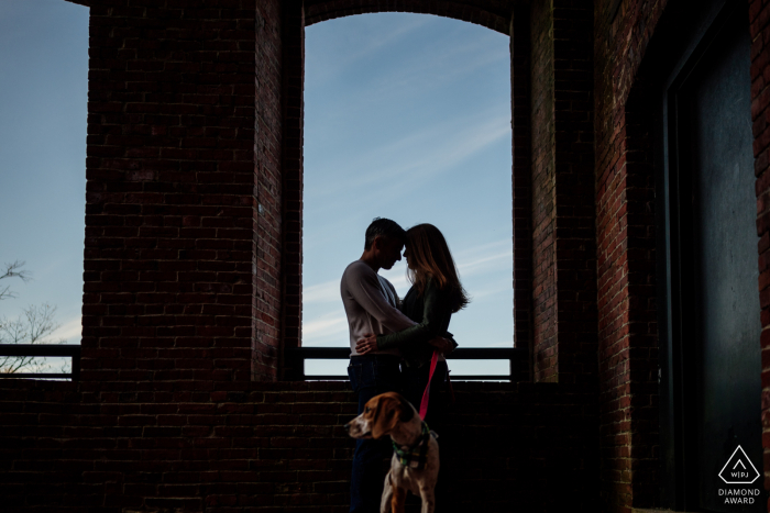 An after the marriage proposal Lowell engagement photograph in Massachusetts for A couple posing in silhouette with their dog An after the marriage proposal Lowell engagement photograph in Massachusetts for A couple posing in silhouette with their dog