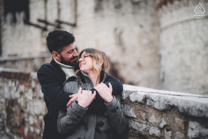 Elle a dit oui, Brescia Castel, Lombardie, Italie après une séance photo de demande en mariage avec de jeunes amoureux s'embrassant devant un mur de pierre