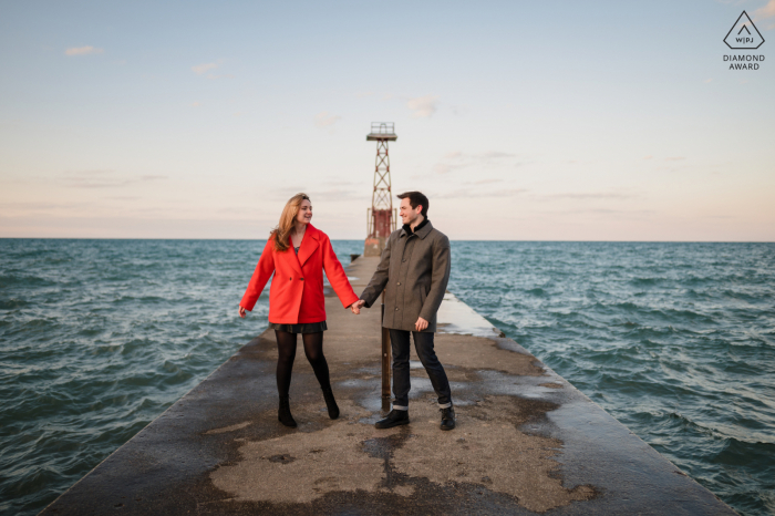 Elle a dit oui, séance photo après la demande en mariage au lac Michigan à Chicago, Illinois pour un couple marchant le long du lac près de Montrose Beach