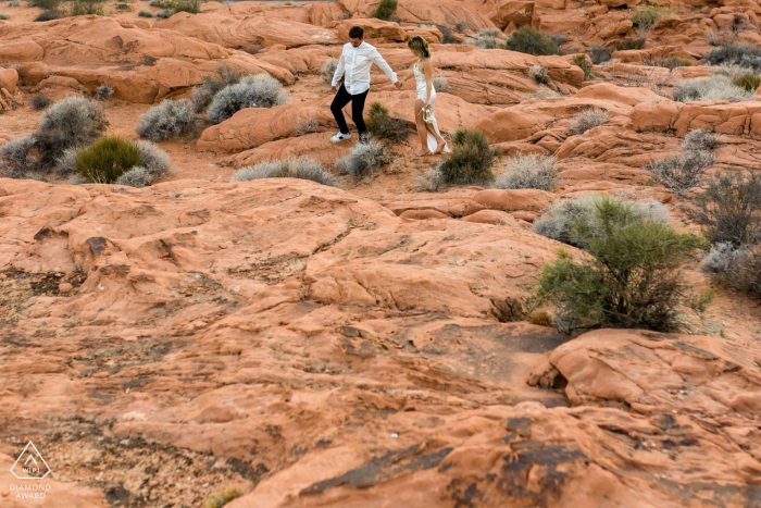 Eine Verlobungsfotosession nach dem Heiratsantrag im Valley of Fire, Las Vegas, NV für ein Brautpaar, das über die roten Felsen geht