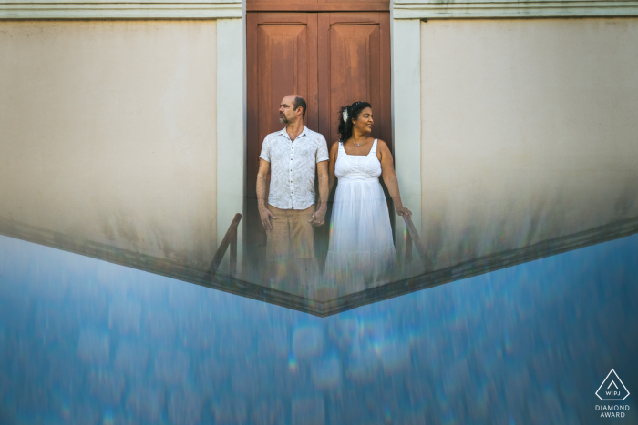 An after the wedding proposal engagement picture session in Maceio, Brazil showing a couple holding hands with a prism reflection