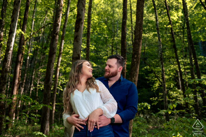 Ela disse que sim, sessão de fotos pós-proposta de casamento em Pigeon Forge, TN com o casal se abraçando no meio da floresta verde das montanhas esfumaçadas