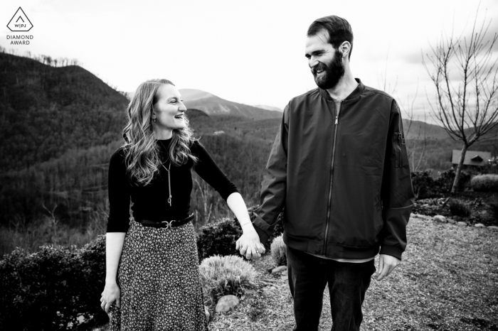 Réservez la date à Gatlinburg. Tennessee portrait du couple se tenant la main et riant au sommet de la montagne Anakeesta Réservez la date à Gatlinburg. Tennessee portrait du couple se tenant la main et riant au sommet de la montagne Anakeesta