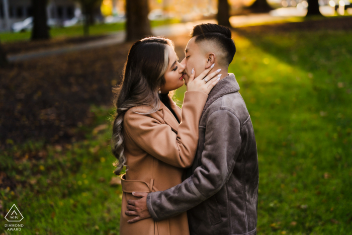 Un couple de Melbourne pose dans le parc sous les arbres et les ombres pour des portraits amusants pour annoncer leurs fiançailles