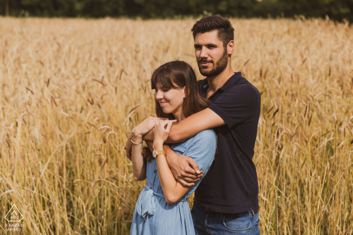 Um casal moderno de Bordeaux posa para um retrato de anúncio rural em um campo de seu noivado na França