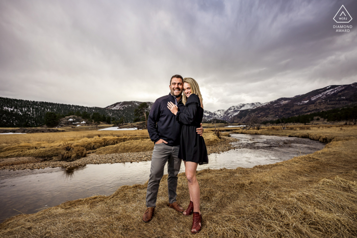 Un couple du Colorado pose ensemble pour un portrait de la vallée alors qu'ils se préparent à annoncer leur engagement RMNP