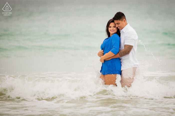 Casal carioca posa para retratos divertidos nas ondas da praia para anunciar o noivado em Arraial do Cabo