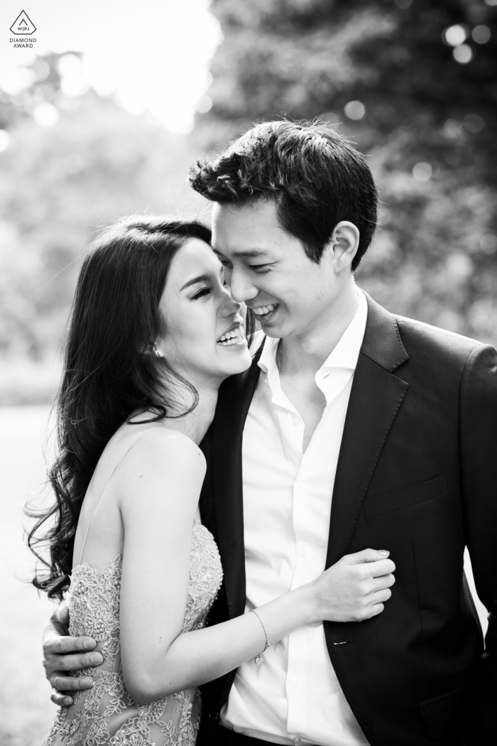 A London couple with BW vintage style poses for this Hyde Park engagement announcement portraits in Central London at a Royal Park near the entrance to Kensington Palace