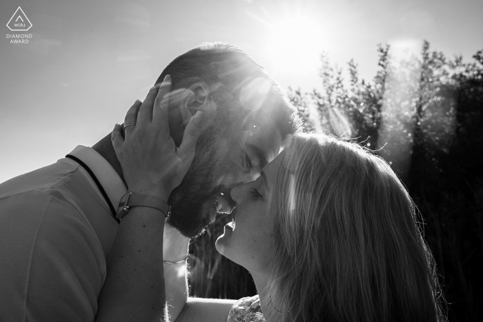 A France modern couple poses during a BW Sunset kiss for their announcement portrait of their Lac de Bouzey Epinal engagement