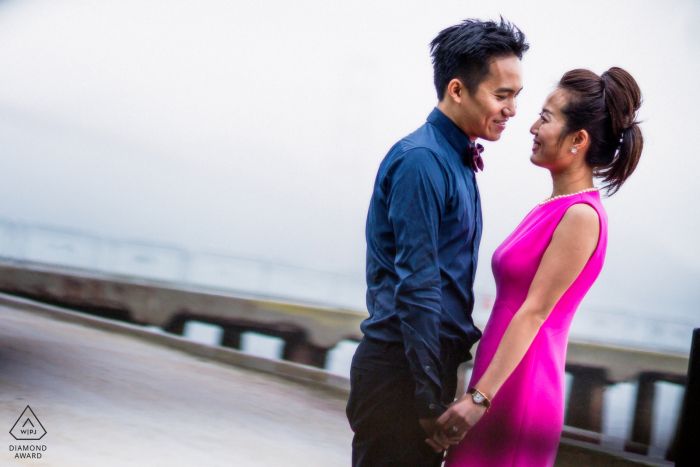 A newly engaged San Francisco couple poses outdoors for an engagement announcement portrait showing the loving couple in the fog and mist at the bay