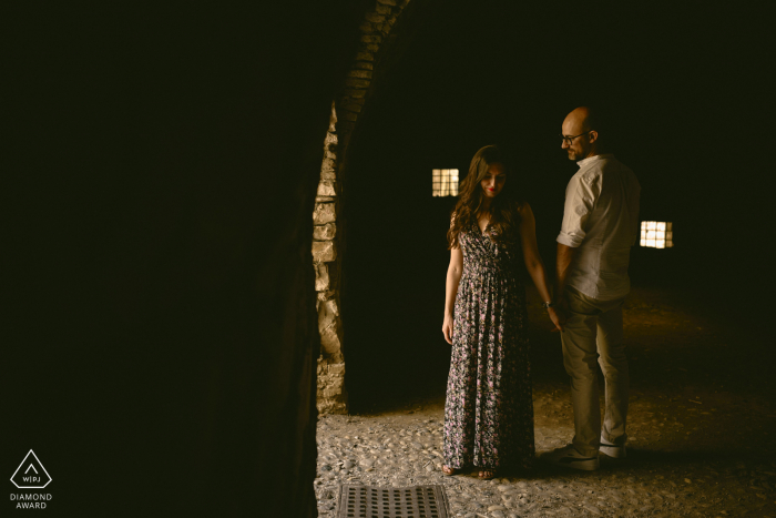 A Italy couple together for an engagement announcement portrait session in Brescia, Lombardy from the top of the Cidneo Hill, the Castle is one of the most fortified complexes in Italy 