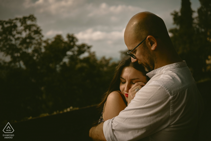 An Italian couple with intimate poses for engagement announcement portraits at Brescia Castle with some warm hugs of love