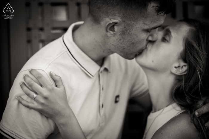 Venice couple posing for an Italy pre wedding announcement shot during a kiss with a freshly offered engagement ring 