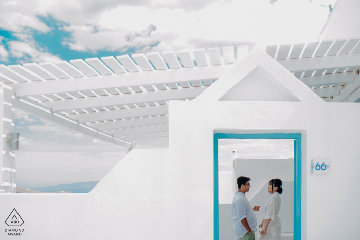 Imagem do portfólio de fotografia de noivado de Santorini com um casal grego no Andromeda Villas Resort desfrutando de seu quarto de hotel