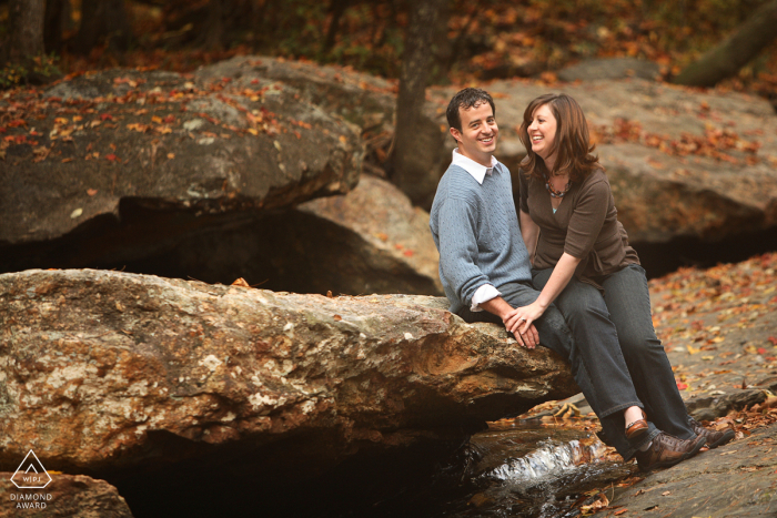 Atlanta lifestyle couples photography session at a family farm showing the pair laughing while posed on rock 