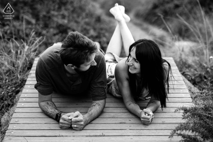 Sesión de fotografía de estilo de vida de San Juan de Luz en los Pirineos Atlánticos, Francia, que muestra a la pareja en blanco y negro durante una pequeña pausa cómplice en un pontón