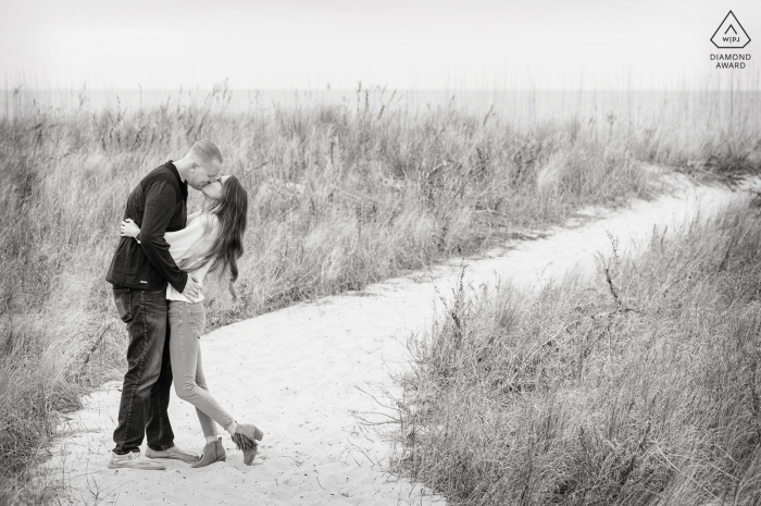 An Outlook Beach, Fort Monroe lifestyle couple portrait in Hampton, Virginia along a twisted walking path through the grass