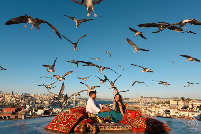 Une séance de portrait d'engagement de style de vie à Istanbul, en Turquie, pour un couple profitant d'une aventure sur le toit avec des oiseaux au-dessus