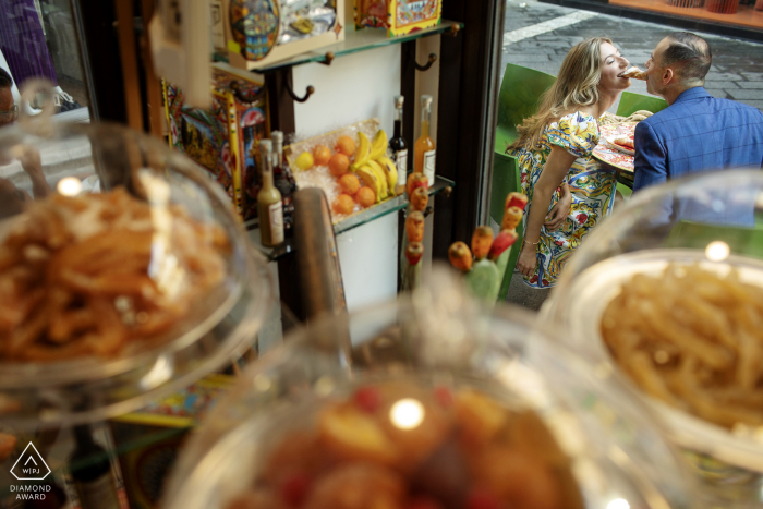 Fotografia di fidanzamento sullo stile di vita di Taormina di una coppia italiana con un tema siciliano e fidanzati che mangiano i famosi cannoli siciliani