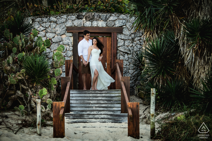 A lifestyle engagement portrait session in Niteroi, Rio de Janeiro for a couple posing at the entrance door to a stone building at the top of a small set of stairs A lifestyle engagement portrait session in Niteroi, Rio de Janeiro for a couple posing at the entrance door to a stone building at the top of a small set of stairs