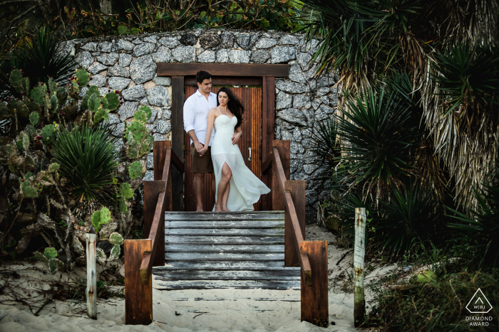 Uma sessão de retratos de noivado de estilo de vida em Niterói, Rio de Janeiro, para um casal posando na porta de entrada de um prédio de pedra no topo de uma pequena escada