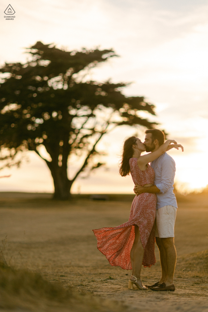 Bretagne-Lifestyle-Fotosession in Ille-et-Vilaine, Bretagne, zeigt ein Paar, das sich bei Sonnenuntergang auf einem Golfplatz umarmt