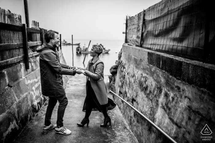 Bordeaux untraditionelles Lifestyle-Engagement-Porträt eines französischen Paares, das sich am Bootsanlegeplatz am Wasser amüsiert